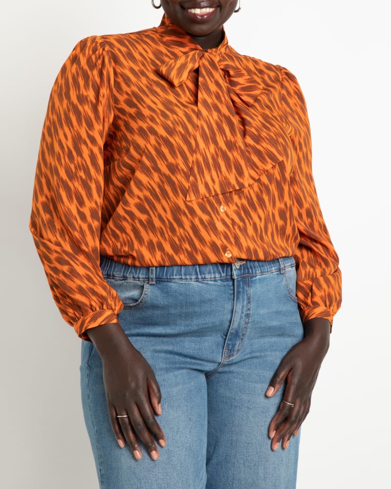 Front of a model wearing a size 14 Reina Tie Neck Blouse in New Natural by ELOQUII. | dia_product_style_image_id:236630